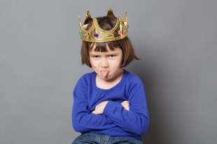 Kid wearing toy crown and poking tongue out