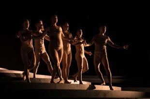 pregnant dancers. A ensemble scene from a contemporary dance work on a darkened stage being performed by six dancers one of whom is 30 weeks pregnant.