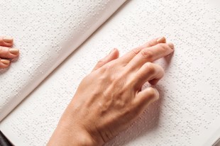 Braille. A woman's hand reading Braille.