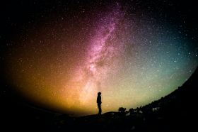 Pitch. Image is a silhouetted figure stands against a photo of the Milky Way in all its cosmic splendour.
