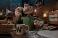 Aardman. Image is a claymation figure of a man with a big mug with a W on it in front of him. He is sitting at a table and holding up a small card.