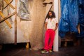 Ramesh Mario Nithiyendran. Photo of man in red pants with long hair in exhibition.