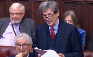 Melvyn Bragg during his speech in the House of Lords, video still. Image: Courtesy of Campaign for the Arts. A British man in his 70s with grey hair and glasses giving a speech among other members in the House of Lords.