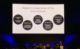 Conference speaker in darkened room with presentation image on AI